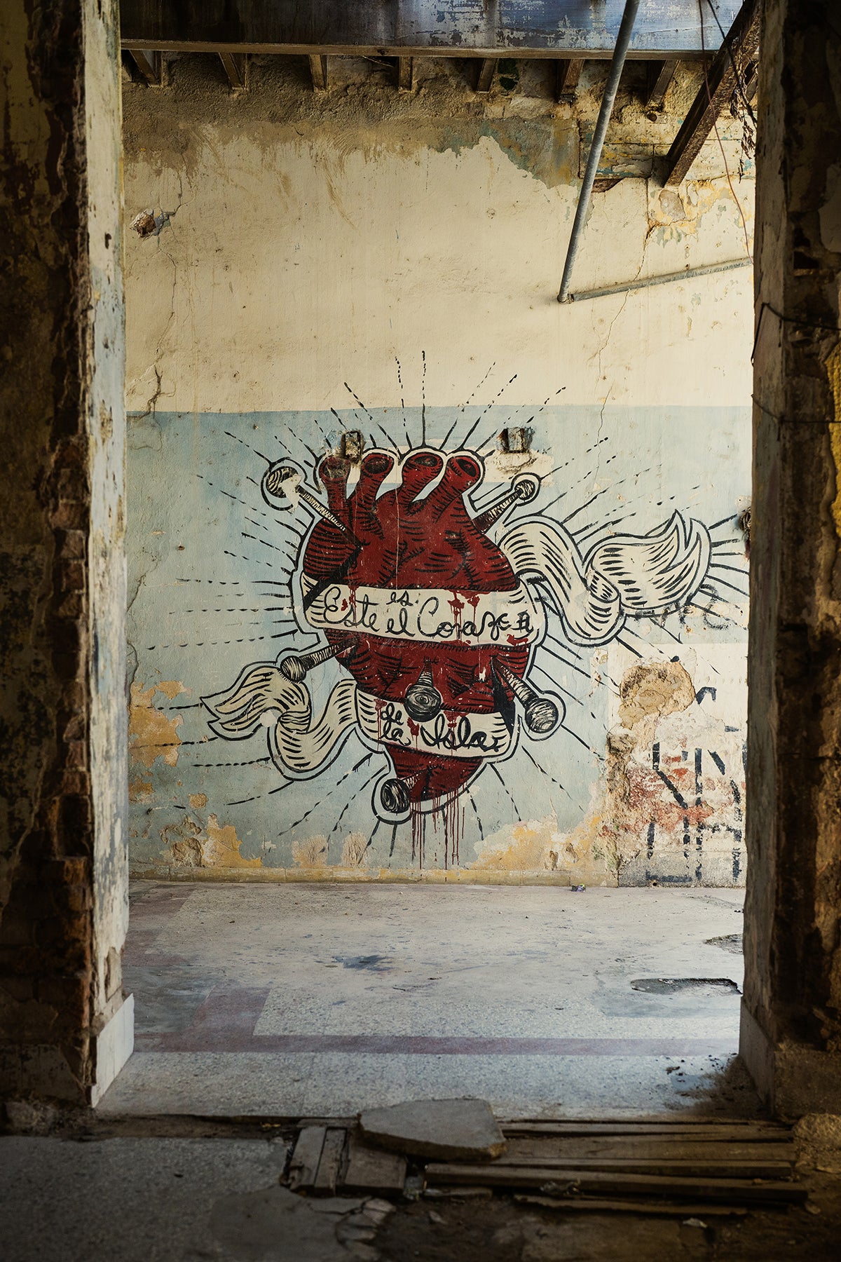 Art print of a mural of a heart with text on a wall in an abandoned building in Cuba.