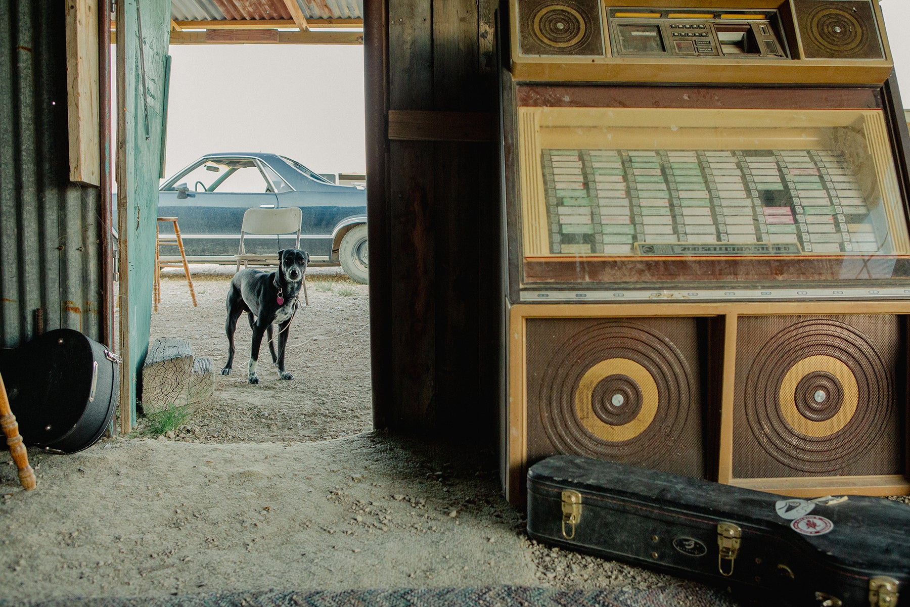 Fine art print of a vintage jukebox in a rustic setting with a dog and car in the background.